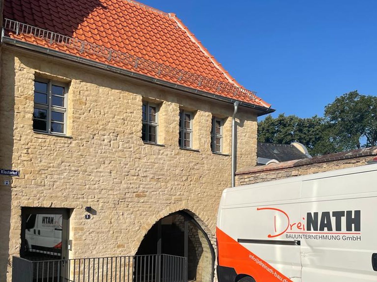 Saniertes Gebäude am Klosterhof: Natursteinfassade mit Torbogen und neuem Ziegeldach