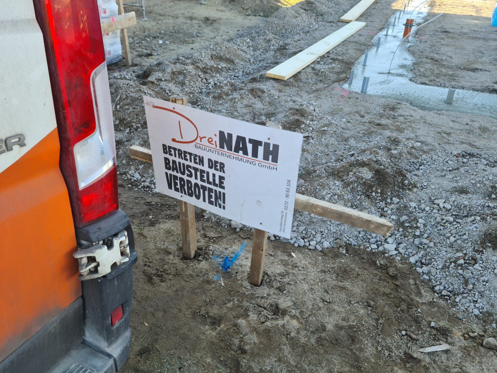 Frisch betonierte Fundamente mit Dreinath-Baustellenschild