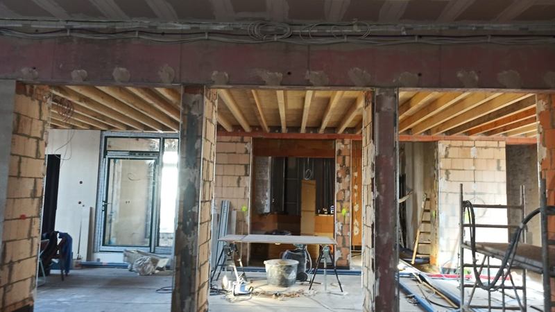 Neue Stahlträger unter einer Holzbalkendecke im Bestand