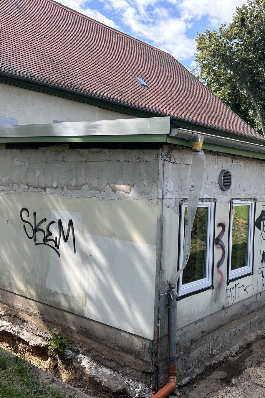 Trauerhalle Oschersleben: Anbau mit Graffiti, schadhaftem Putz und freigelegtem Sockel